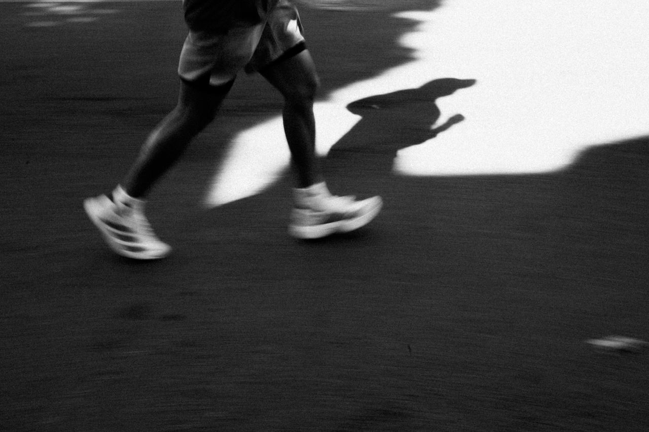 The Art of Drawing Readers In: Your attractive post title goes here Captivating black and white image of a runners shadow casting on the pavement in motion.